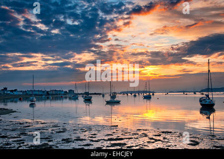 Yachten, die bei Sonnenaufgang auf die Menai Straits, Beaumaris, Isle of Anglesey, North Wales, UK Stockfoto