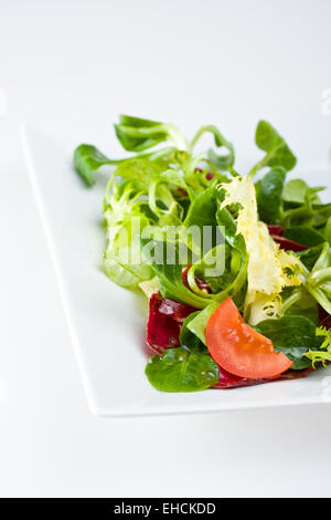 Detail von gemischtem Salat auf einem weißen Teller Stockfoto