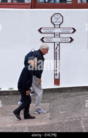 Wanderer, vorbei an dem Schild zeigt Entfernungen Endland, John O'Groats, Caithness, Schottland Stockfoto