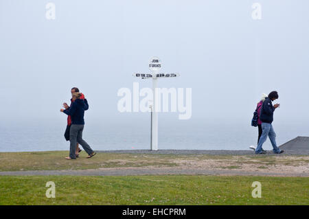 Wanderer, vorbei an dem Schild zeigt Entfernungen Endland, John O'Groats, Caithness, Schottland Stockfoto