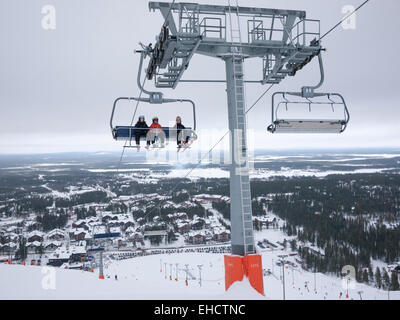 Eine Sesselbahn, die Skifahrer auf den Berg an der Skistation Levi, Lappland Finnland in Grau bedeckt Bedingungen Stockfoto