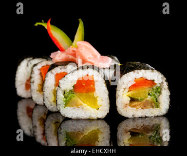 Auf schwarzen Tisch serviert köstliche Sushi-Rollen Stockfoto