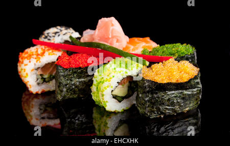 Auf schwarzen Tisch serviert köstliche Sushi-Rollen Stockfoto