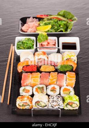 Auf schwarzen Teller und Stein serviert köstliche Sushi-Rollen Stockfoto