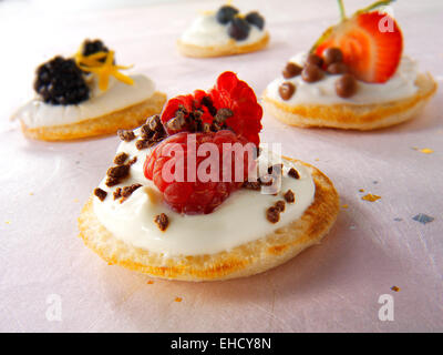 Süße blinis Canipe, Blini gekrönt mit Creme fraiche, Himbeere und Chocolate Chips Stockfoto