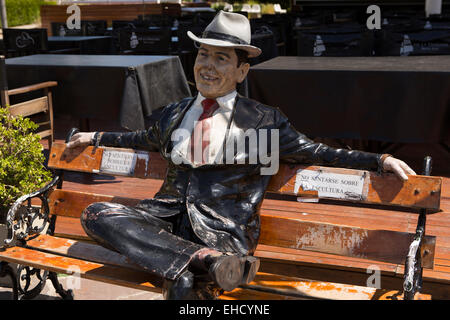 Argentinien, Buenos Aires, Puerto Madero, Kai Skulptur gut gekleideter Mann saß auf der Bank im Sonnenschein Stockfoto