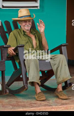 Vertikale Ansicht eines alten kubanischen Mann sitzt auf seiner Veranda in einem Schaukelstuhl. Stockfoto