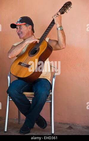 Vertikale Porträt eines Mannes spielen die spanische Gitarre und Gesang an einer Straßenecke in Kuba. Stockfoto