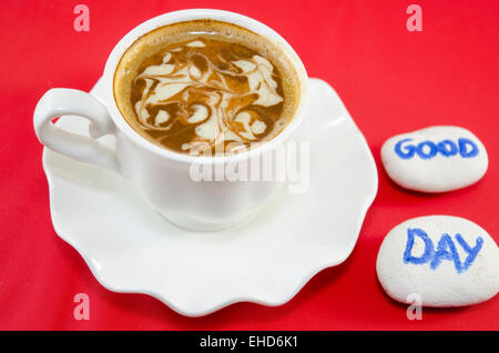 Weiße Tasse Kaffee mit dekorierten Schaum und Felsen sagen: "Guten Tag" Stockfoto