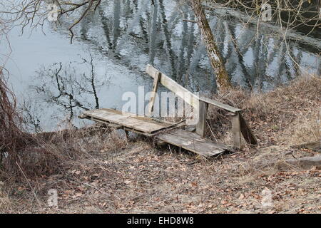 alte hölzerne Stege unter Kristall Süßwasser des Flusses Wald Stockfoto