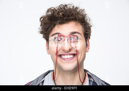 Lustige junger Mann durch die kleine Brille in die Kamera geschaut Stockfoto