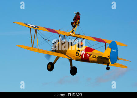 Boeing Stearman A75L-300 Kaydet G-CGPY im Flug über Breighton Flugplatz mit Flügel-Walker am Flügel Stockfoto