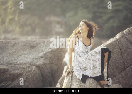 Mädchen in einem Sommerkleid Sommer auf den Felsen Modell Stockfoto