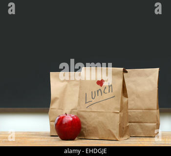 Lunchtüten mit Apple auf der Schulbank Stockfoto