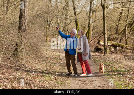 älteres Ehepaar und ihr Hund bei einem Spaziergang an der Elbe am Fluss in der Nähe von Sandkrug, Schnakenbek, Schleswig-Holstein, Deutschland Stockfoto