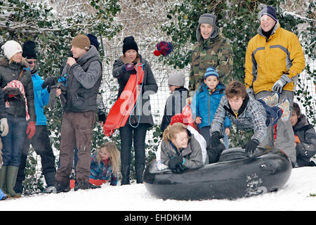 Menschen mit einem Reifen Schlauch als einen Schlitten in Cherry Hill Park in Ely nach starkem Schneefall Stockfoto