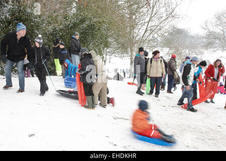 Menschen in Cherry Hill Park in Ely nach starkem Schneefall Rodeln Stockfoto