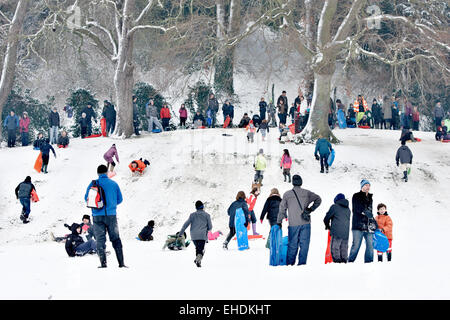 Menschen in Cherry Hill Park in Ely nach starkem Schneefall Rodeln Stockfoto