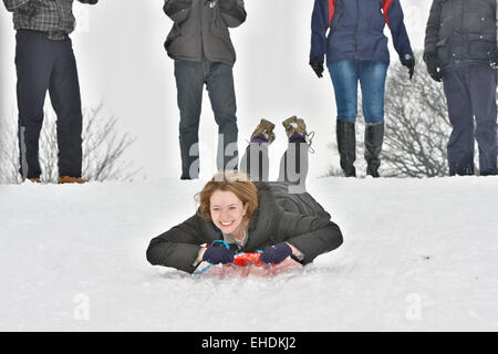 Frau Schlitteln in Cherry Hill Park in Ely nach starkem Schneefall Stockfoto