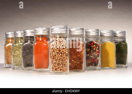 Flaschen von bunten Gewürzen mit grau Stockfoto