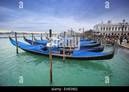 Gondeln vertäut im Wasser Kanal vor Menschen zu Fuß auf Riva degli Schiavoni in Venedig, Italien. Stockfoto