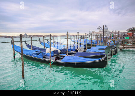 Gondeln vor Anker im Wasser mit Blick auf Santa Maria della Salute Kirche in Venedig, Italien. Stockfoto