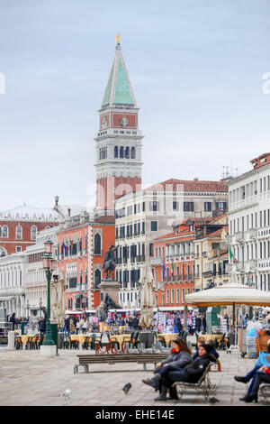 Menschen Sightseeing auf Riva degli Schiavoni mit Blick auf den Glockenturm von San Marco in Venedig, Italien. Stockfoto