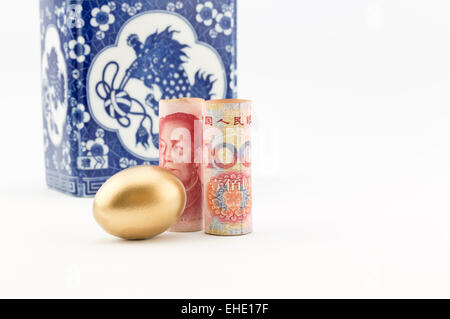 Chinesische Yuan Währung steht mit goldenen Notgroschen vor der alten Porzellan Behälter.  Platz auf der rechten Seite zu kopieren. Stockfoto