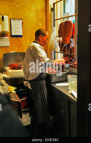 Chinese New Year, Koch bereitet Char Siu Schweinebraten, Young Cheng Restaurant, Lisle Street, London, England, UK Stockfoto