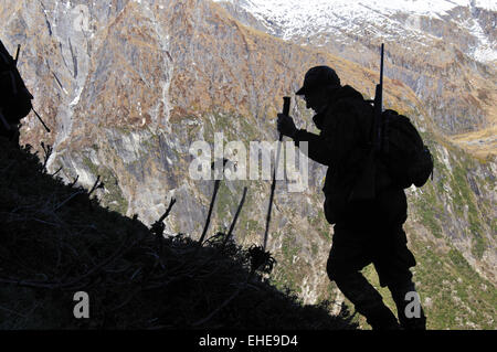 Ein Jäger skaliert die Hänge der Südalpen Neuseelands bei der Suche nach Wildtiere wie Gämsen, Rehe und Tahr Stockfoto