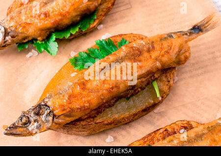 Fish And Chips, Fisch im Teig in Scheiben von Pommes Frites auf Papier und Zeitung Stockfoto