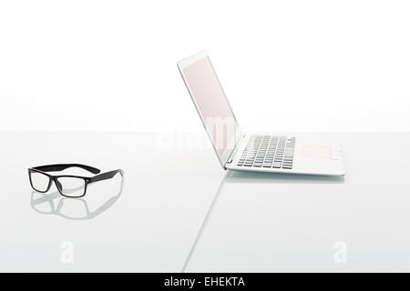 Laptop und Gläser isoliert auf weiss Stockfoto