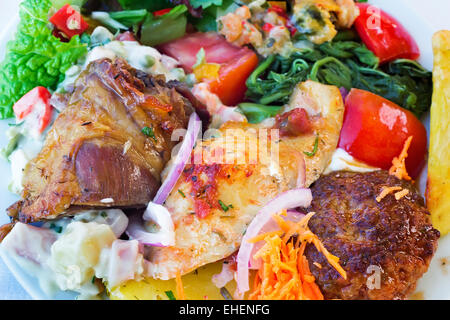Auf dem Tisch auf einem Teller liegt, Eintöpfe und Beilagen aus einer Vielzahl von Gemüse: Karotten, Zwiebeln, Salat, Tomaten. Stockfoto