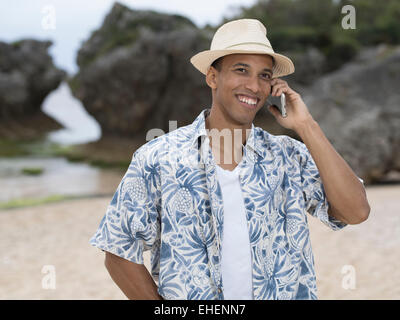 Mann ruft / telefonieren mit Apple Iphone 6 Smartphone am Strand Stockfoto