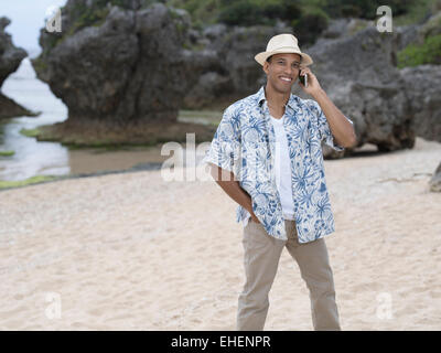 Mann ruft / telefonieren mit Apple Iphone 6 Smartphone am Strand Stockfoto