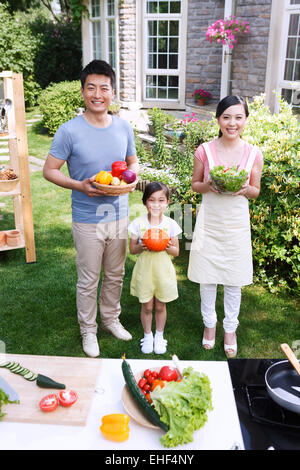 Eine Familie mit drei mit Gemüse in der Outdoor-Küche Stockfoto