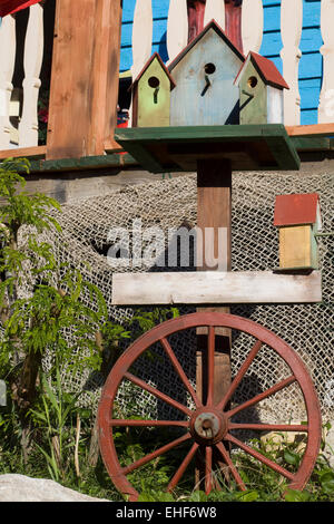 Holz farbig Vogelhäuser auf ein Wagenrad Stockfoto