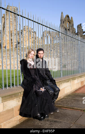 Paar durch die Ruinen von Whitby Gothic Weekender. Stockfoto