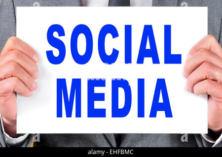ein Mann in einem Anzug hält ein Schild mit den Worten geschrieben in ihr social-media Stockfoto