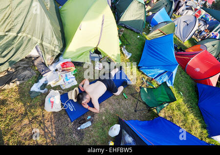 Mann schläft unter den Zelten an Glastonbury Festival, Pilton, Somerset, UK, Juni 2009. Stockfoto