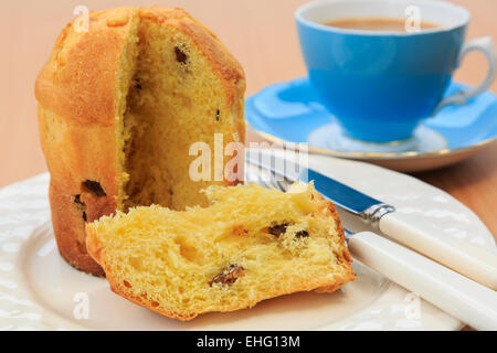 Ein Stück italienische Weihnachten Panettone Obst Brot Kuchen auf einem Teller mit einer Tasse Tee auf eine Tischplatte. England-UK-Großbritannien Stockfoto