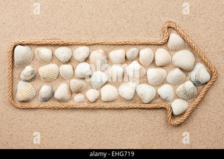 Zeiger des Seils mit Muscheln, auf dem Sand liegen gemacht Stockfoto