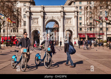 Marble Arch, London, England. Touristen gehen mit gemieteten Zyklen. Stockfoto