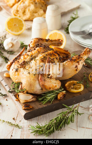 Hausgemachte Zitronen-Kräuter ganzes Huhn auf ein Schneidebrett Stockfoto