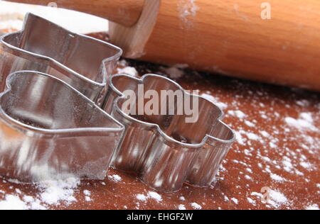 Ausstechformen und Nudelholz liegen am Teig für Kekse, Konzept zum Backen Stockfoto