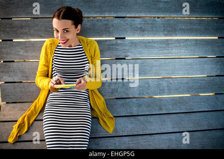 Frau mit Telefon auf Sonnenbank Stockfoto