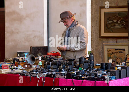 Stall + Standbesitzer mit Vintage-Kameras, Flohmarkt in Logge di Banchi, Piazza XX Settembre, Stadtmitte, Pisa, Toskana, Italien Stockfoto