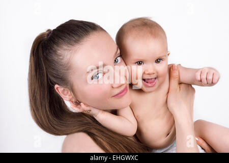 Eine junge kaukasischen Frau hält ein Babymädchen oder junge und lächelnd. Isolierte Porträt. Stockfoto