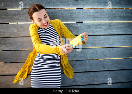 Frau mit Telefon auf Sonnenbank Stockfoto