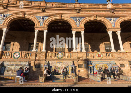 Menschen sitzen im Kachelofen Provinz Nischen an den Wänden von der Plaza de España, Spanien Platz, Luisa in Sevilla. Stockfoto